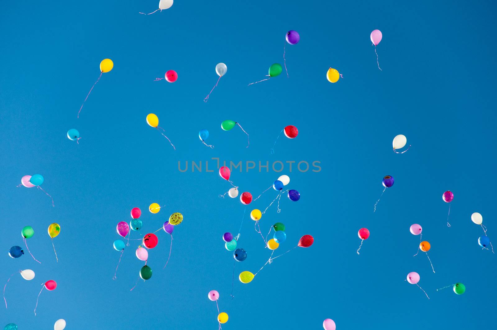 Colorful balloons on a blue sky background by olgavolodina