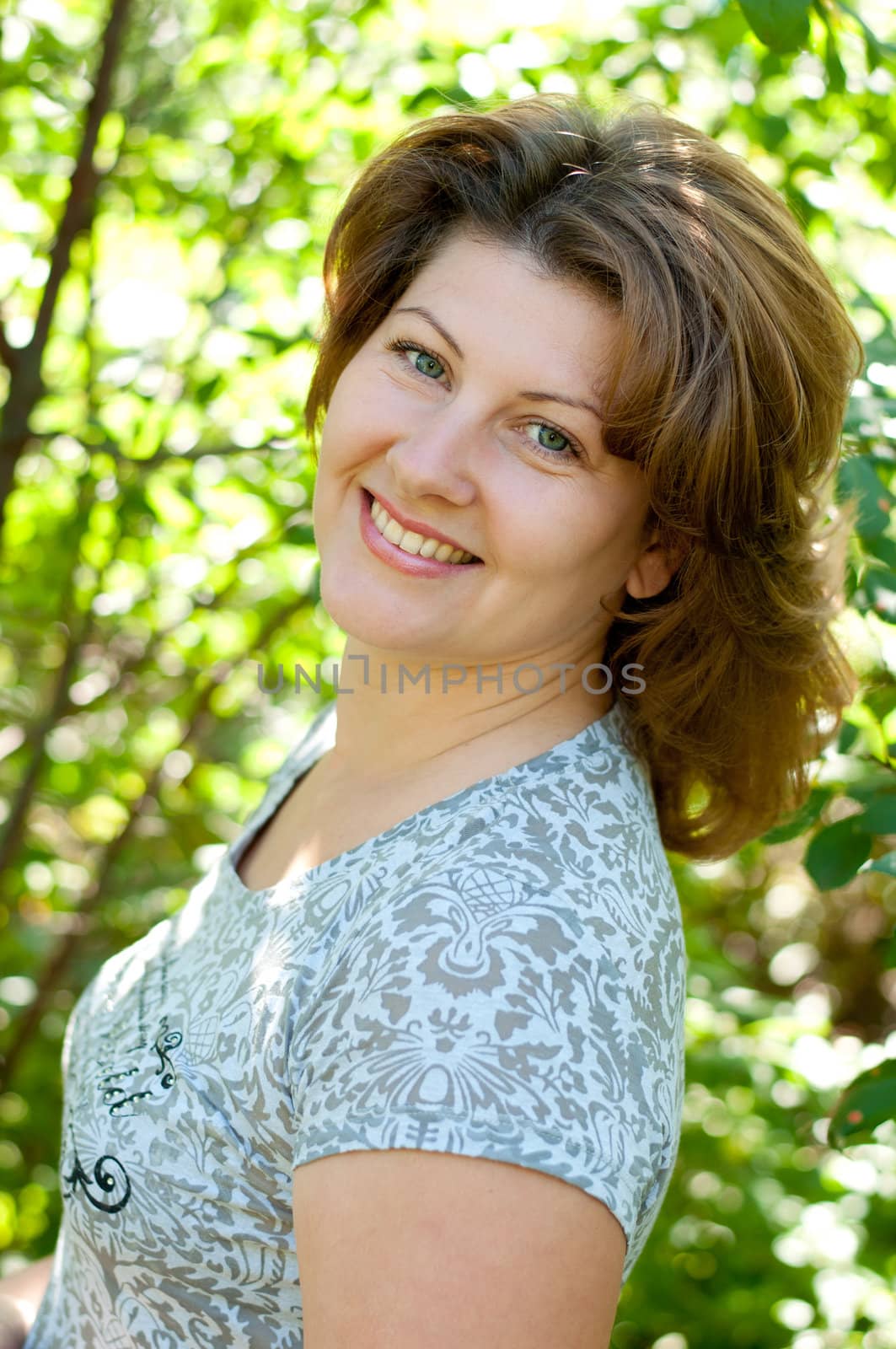 Middle-aged woman in a summer park by olgavolodina