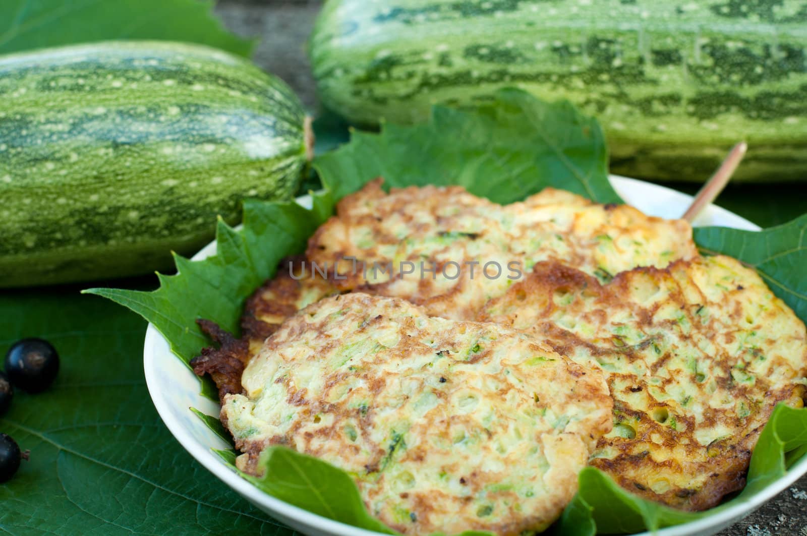 Pancakes with fresh zucchini on grape leaves