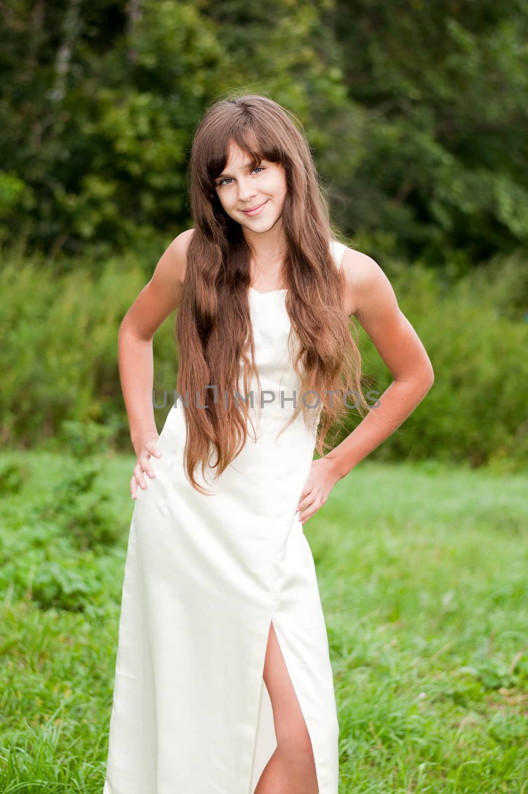 Teenage girl in a white dress on the nature