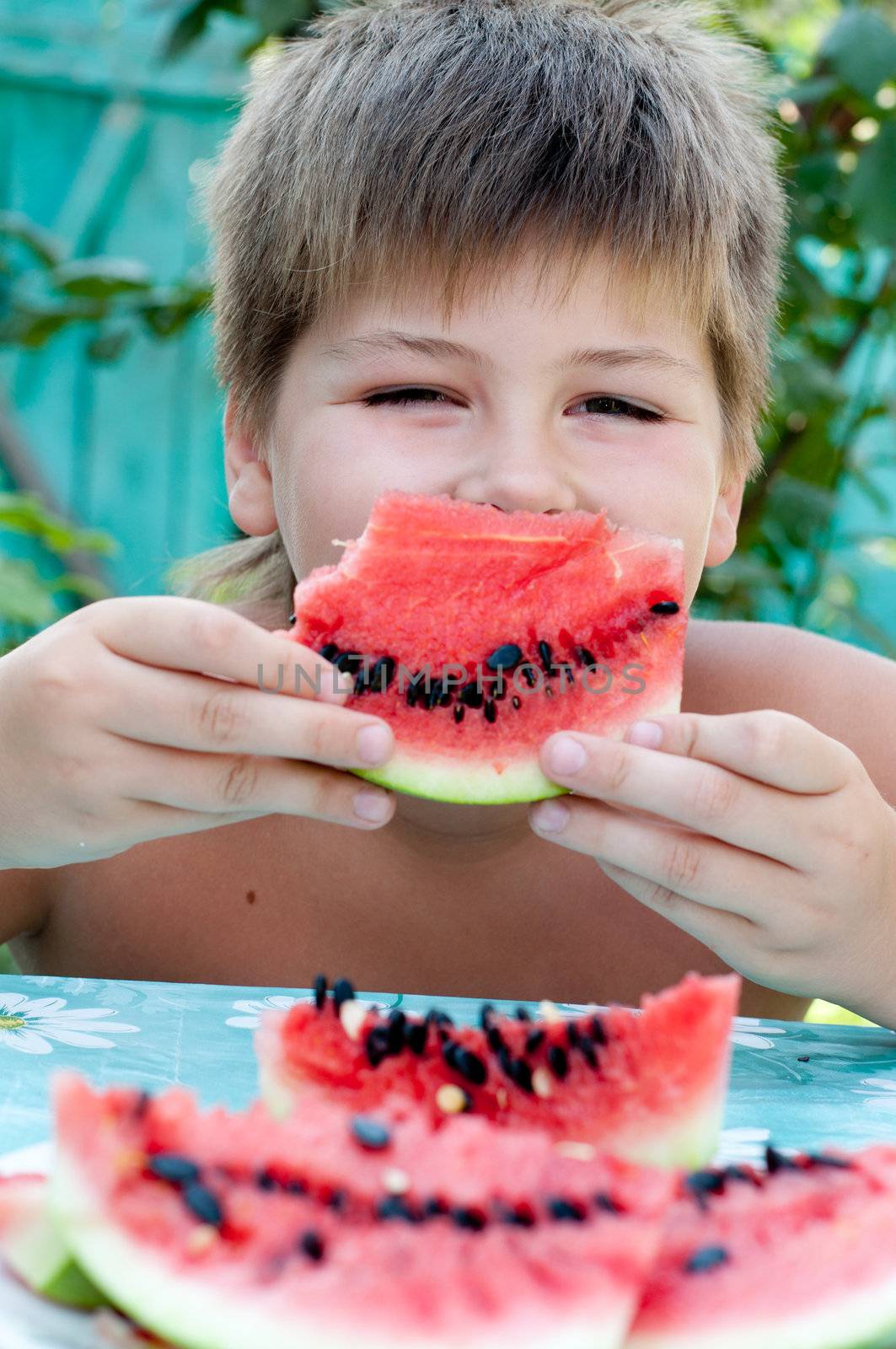 Boy eating a ripe watermelon by olgavolodina