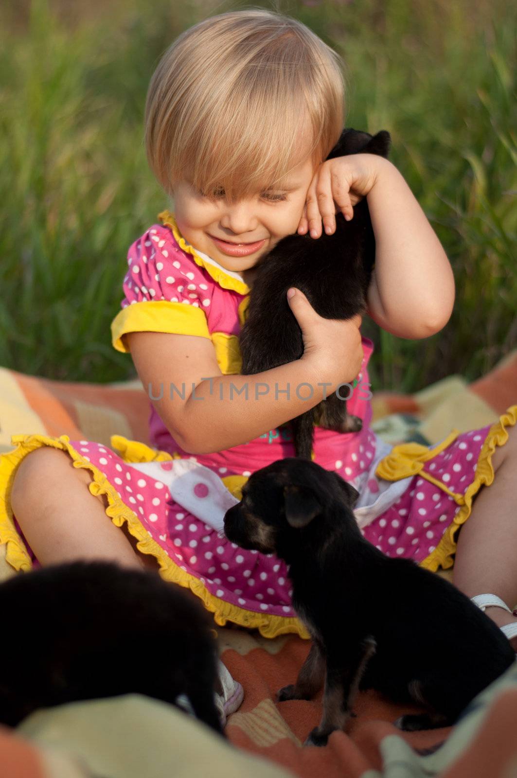 Little girl playing with puppies