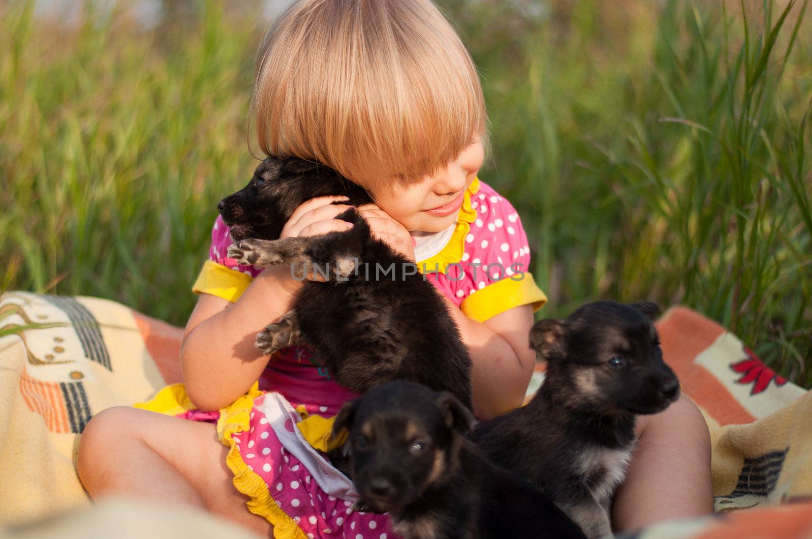Little girl playing with puppies