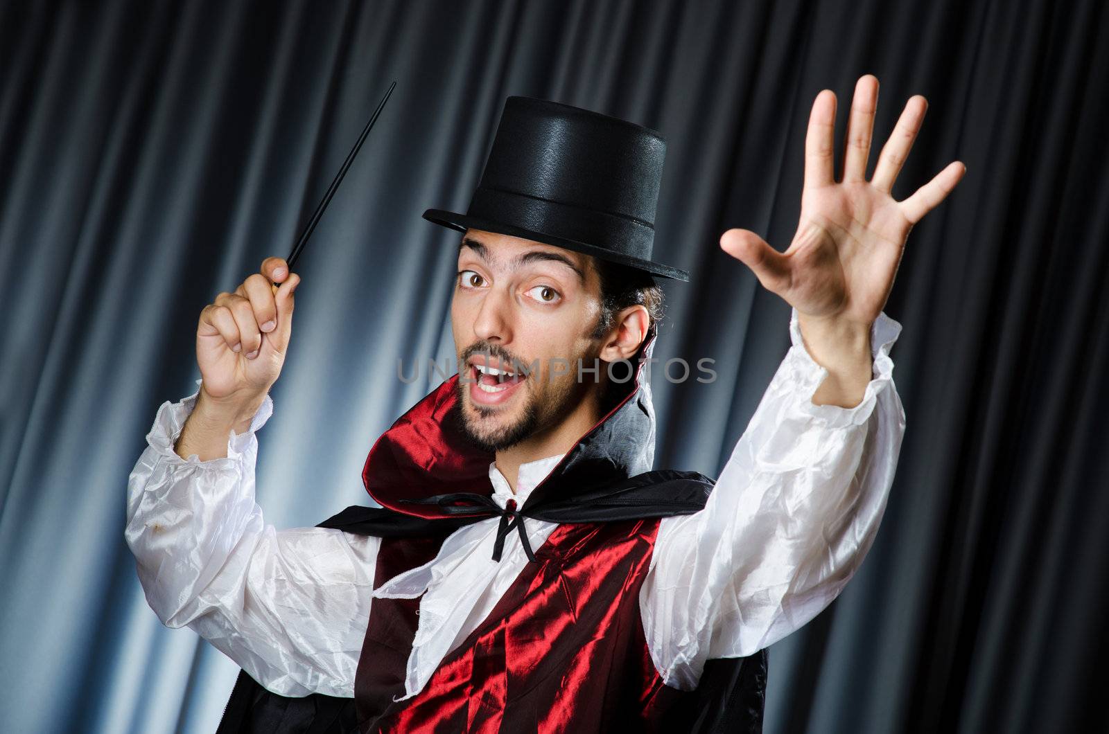 Magician doing tricks in dark room by Elnur