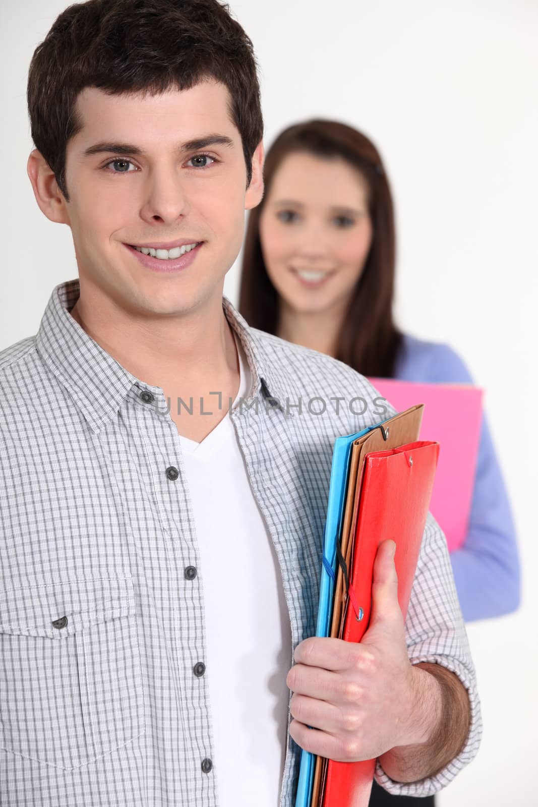 young student all smiles holding files and girl in background by phovoir