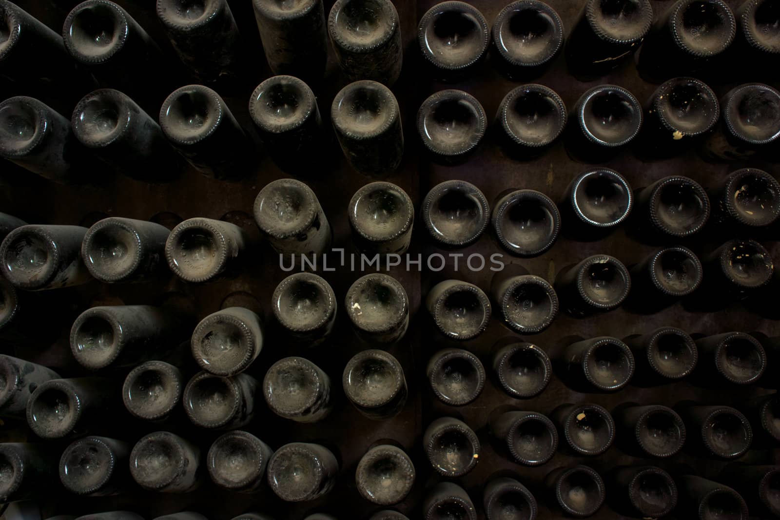 Punts of dusty wine bottles in cellar