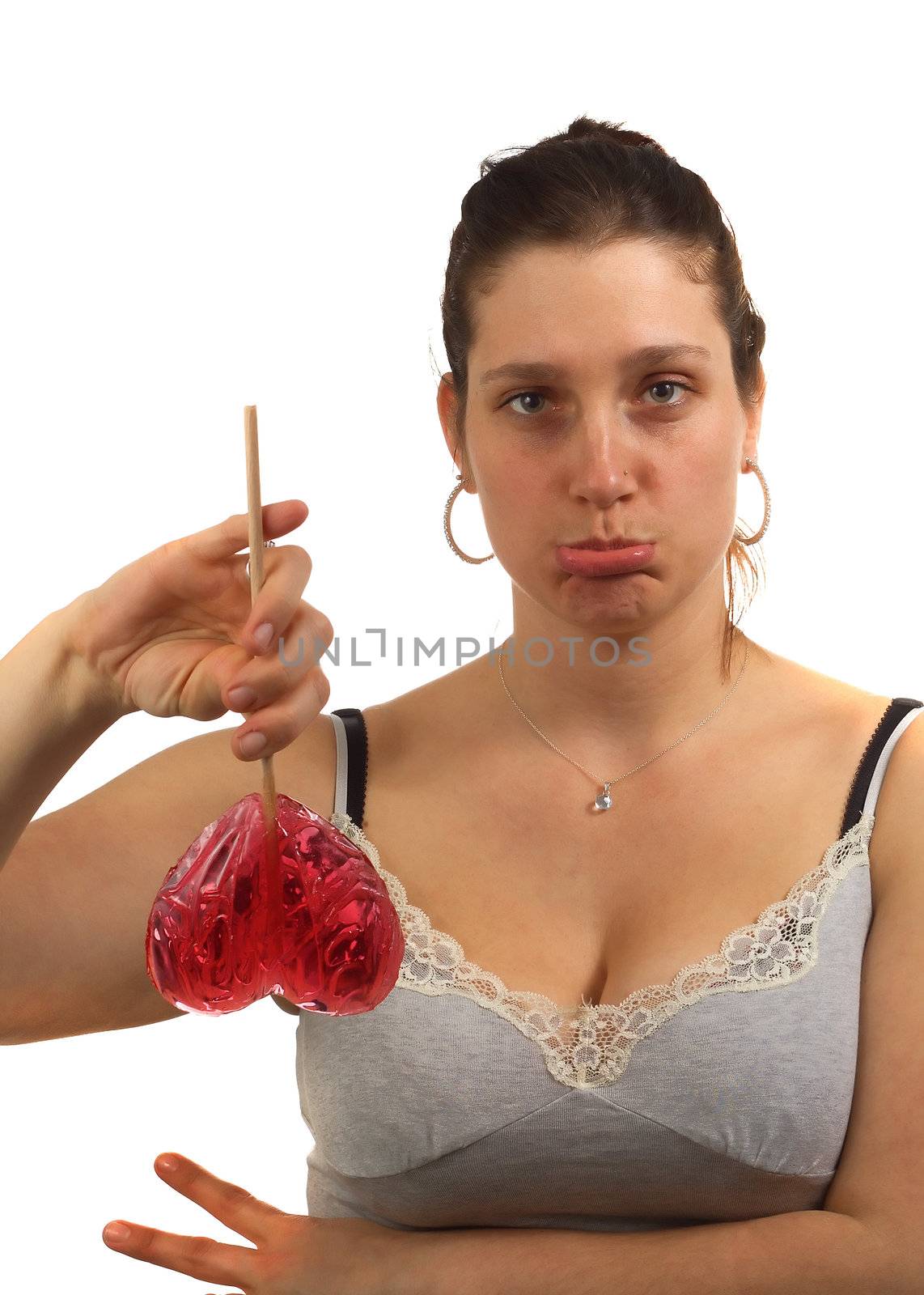 Sad young woman hold heart shaped lollipop upside down by totony
