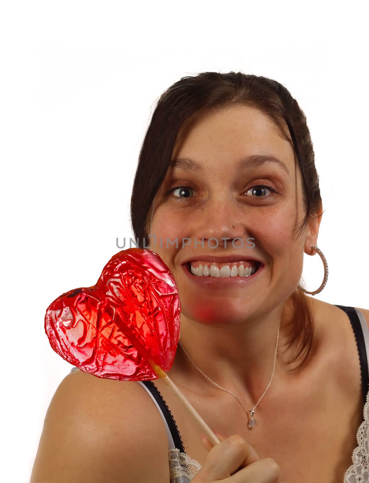 Young woman happy to have received a heart shaped lollipop for Valentine's day, isolated over white