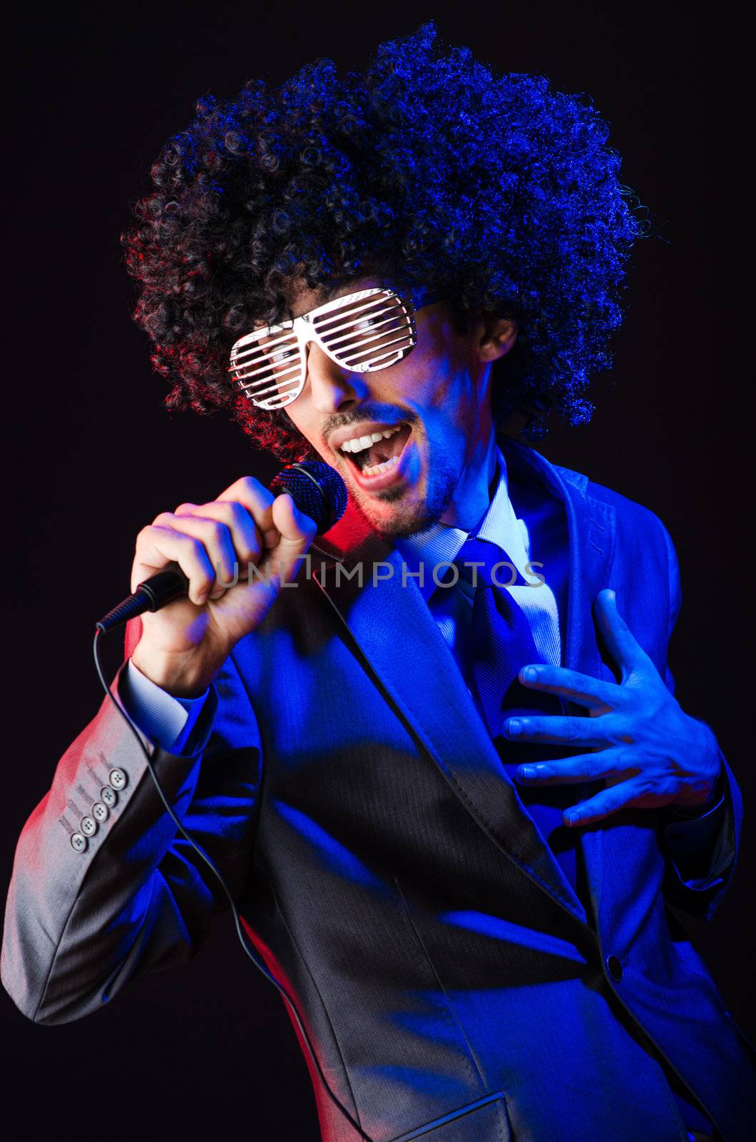 Young singer in afro wig singing at disco