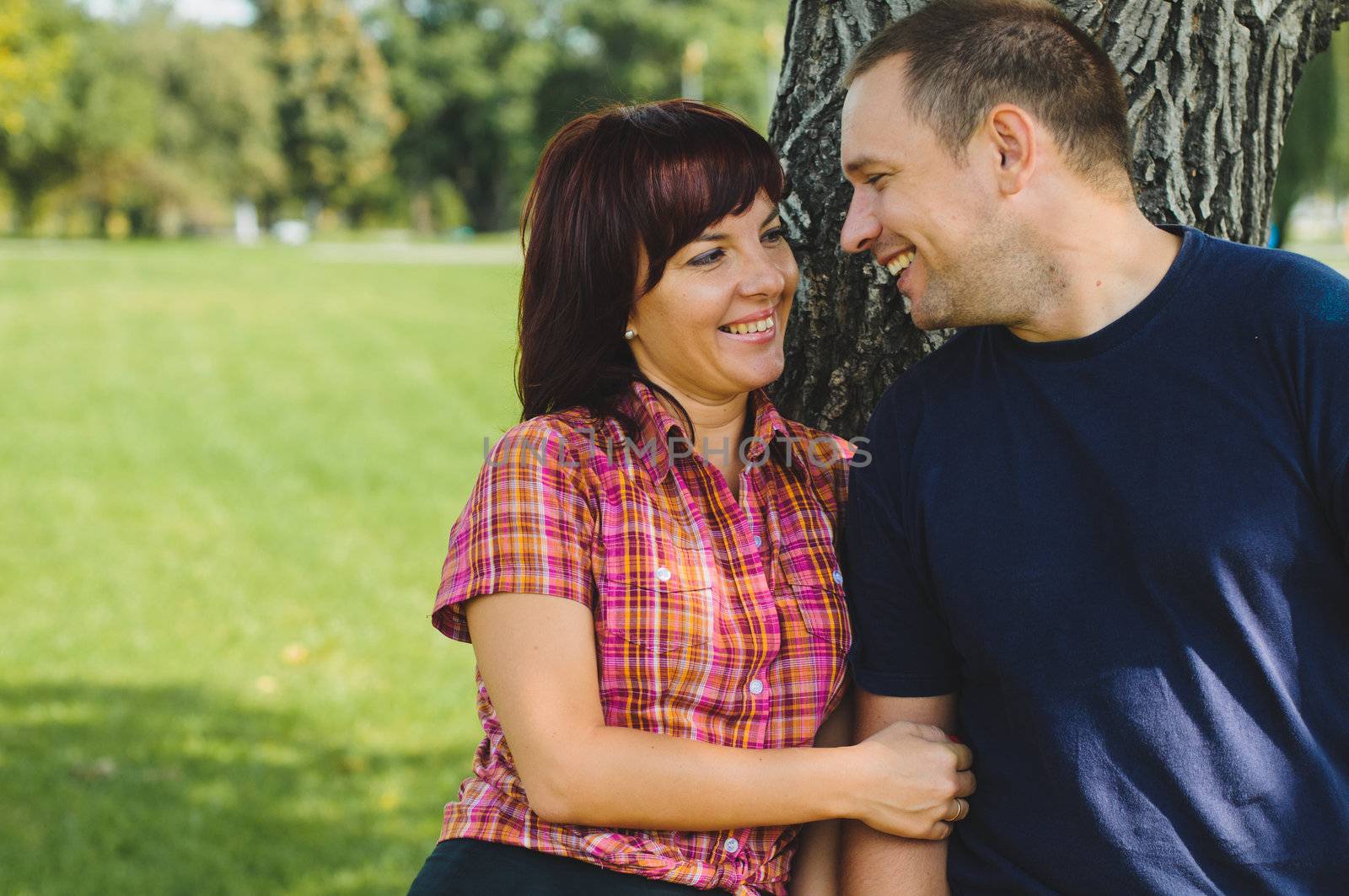 Good looking couple in love smiles each other outdoor