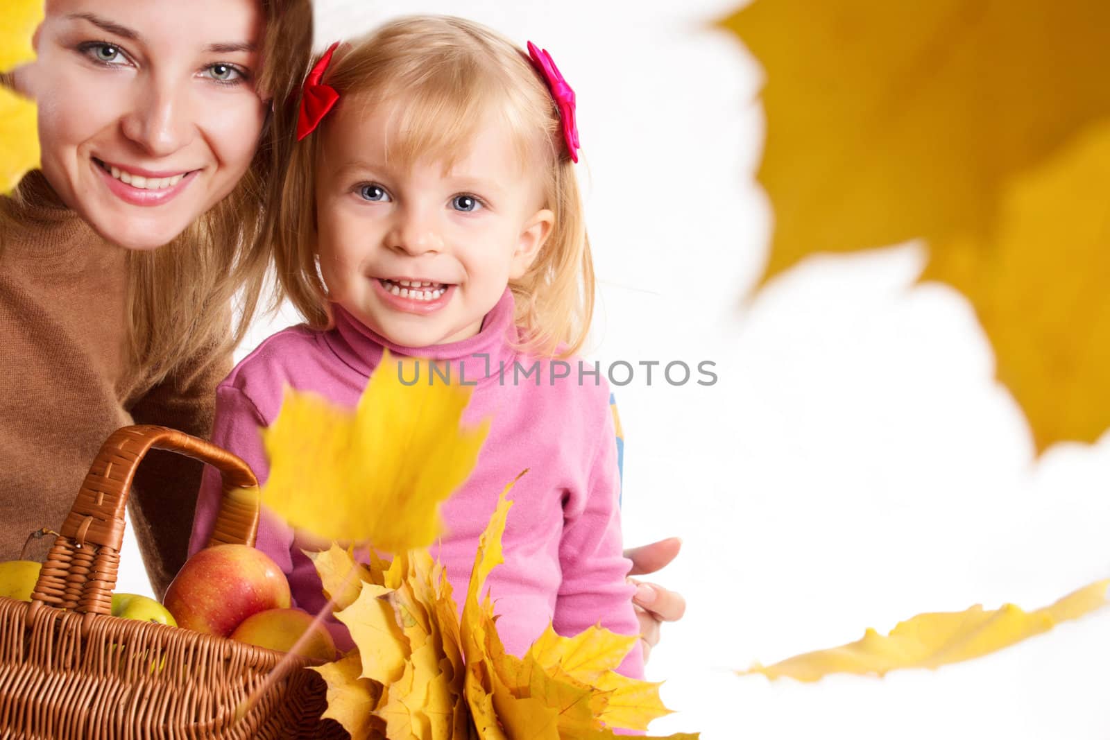 Mother and little daughter with basket and falling yellow leaves
