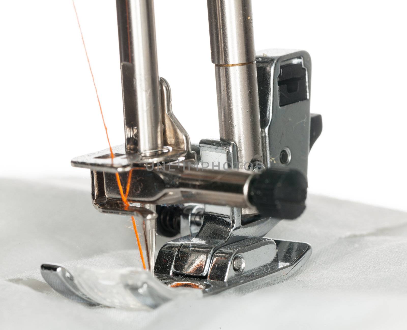 Sewing machine macro sews cloth with orange cotton thread