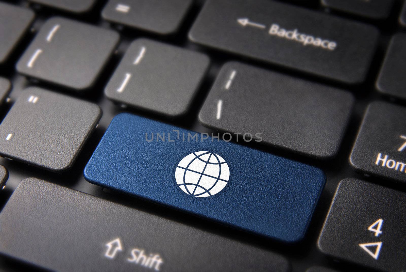 Internet global business concept: blue key with world map icon on laptop keyboard.  Included clipping path, so you can easily edit it.