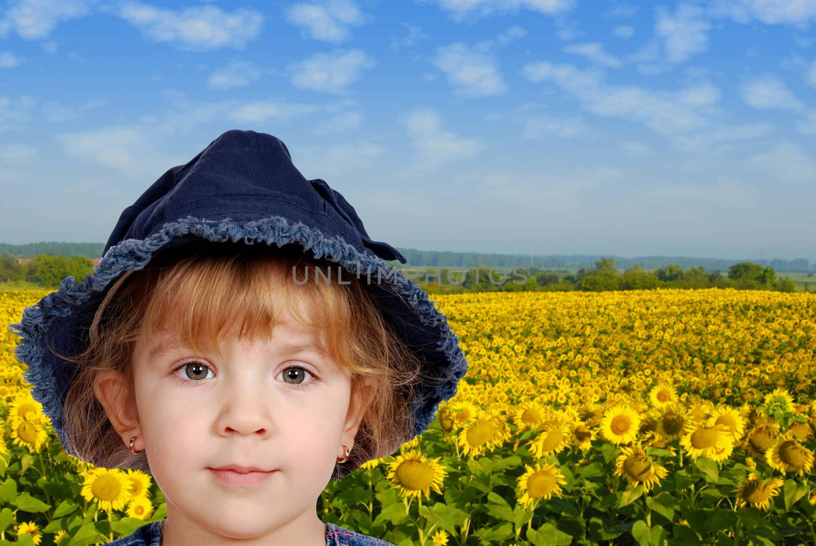 little girl portrait with sunflower field behind