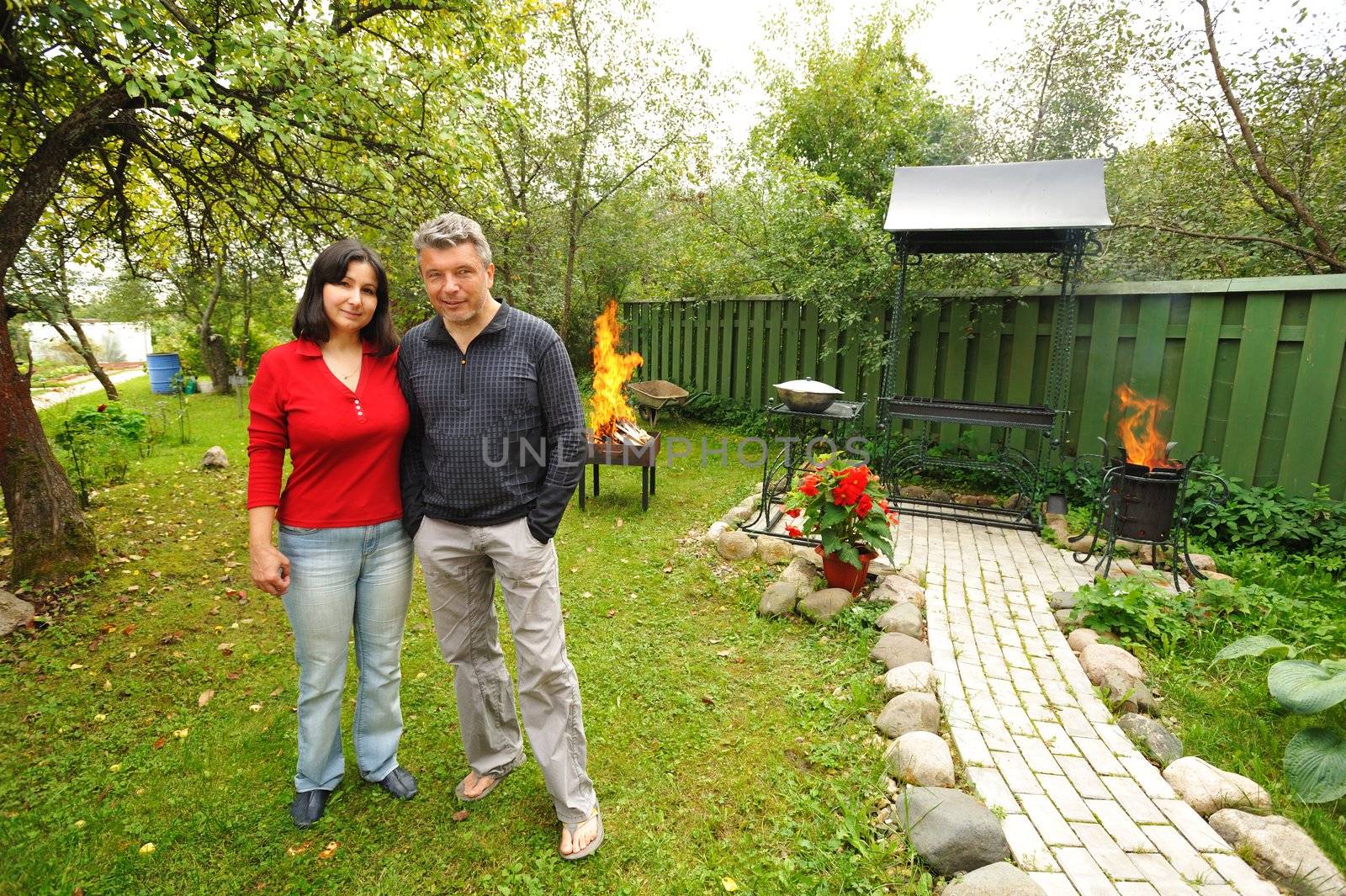 Mature couple at backyard, preparing BBQ