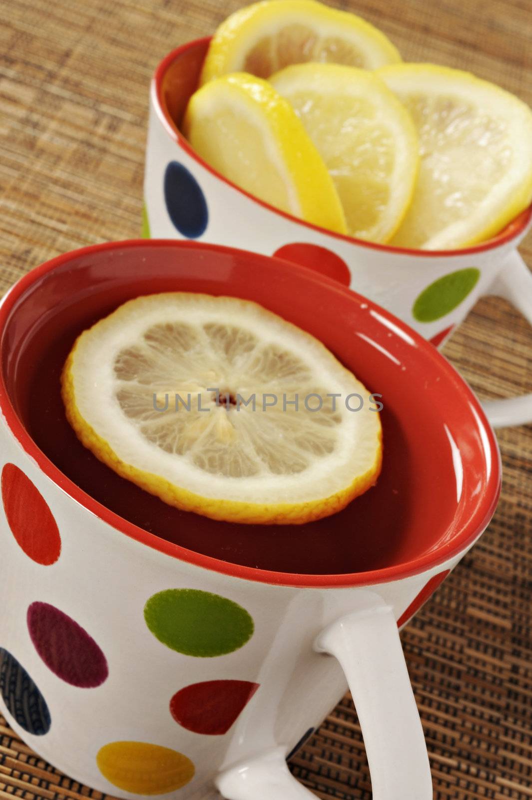 Tea with lemon in polka dot cups by tish1