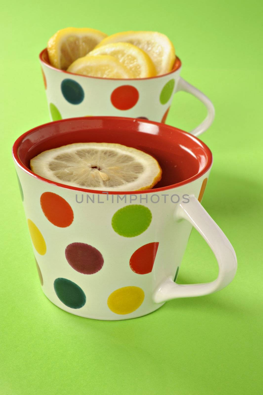 Tea with lemon in polka dot cups by tish1