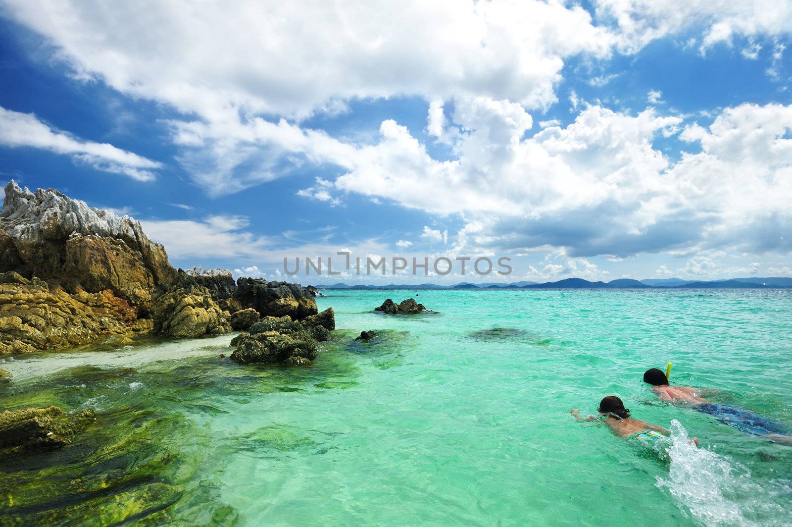 Boys snorkeling at rocky beach in Thailand. Unrecognizable faces.