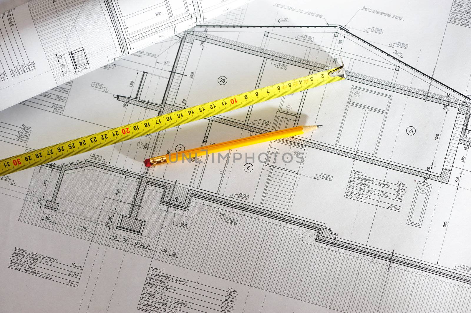 Pencil and tape meausure over house plan blueprints