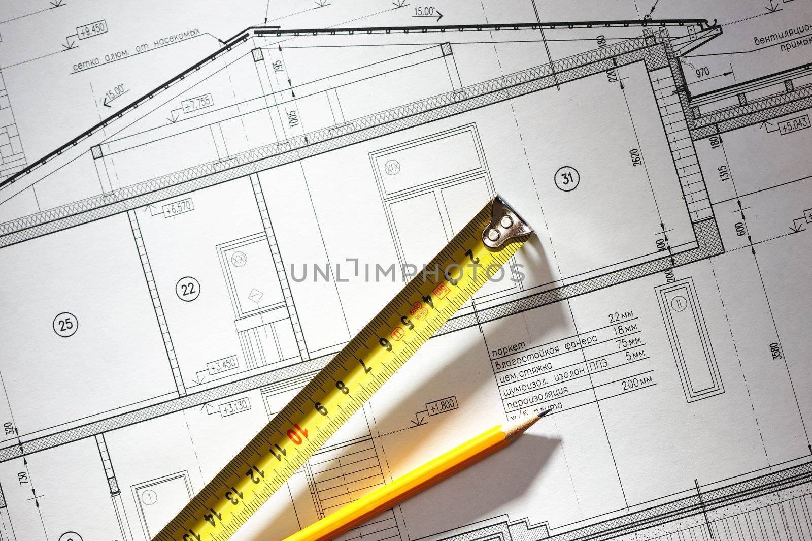 Pencil and tape meausure over house plan blueprints