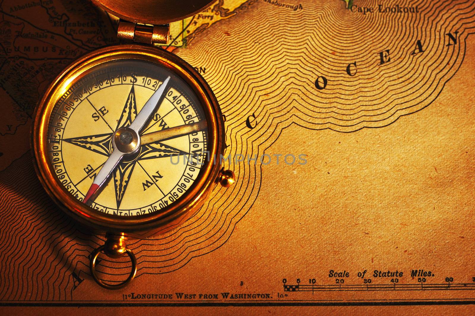 Antique brass compass over old USA map background