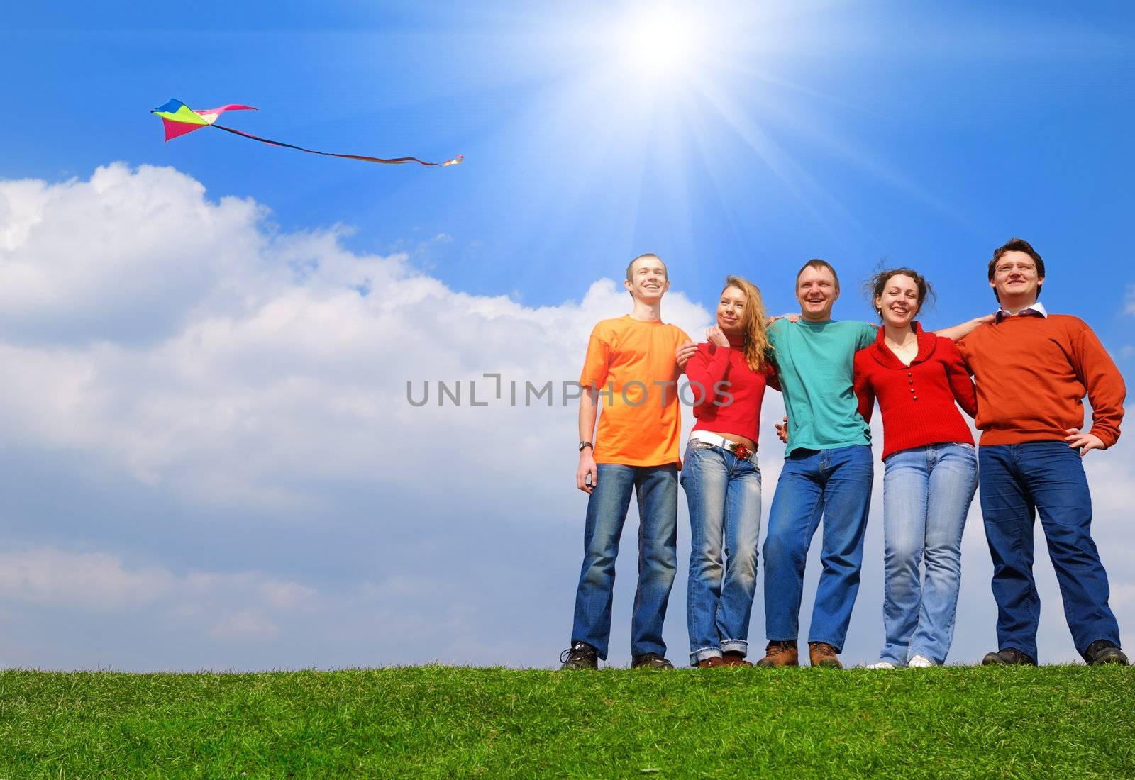 Group of people smiling against blue sky                                    