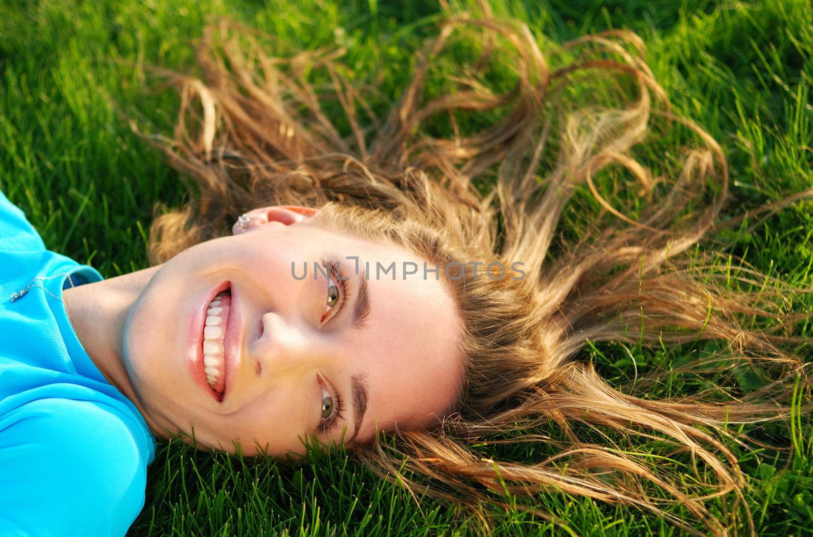 Girl laying on fresh green grass