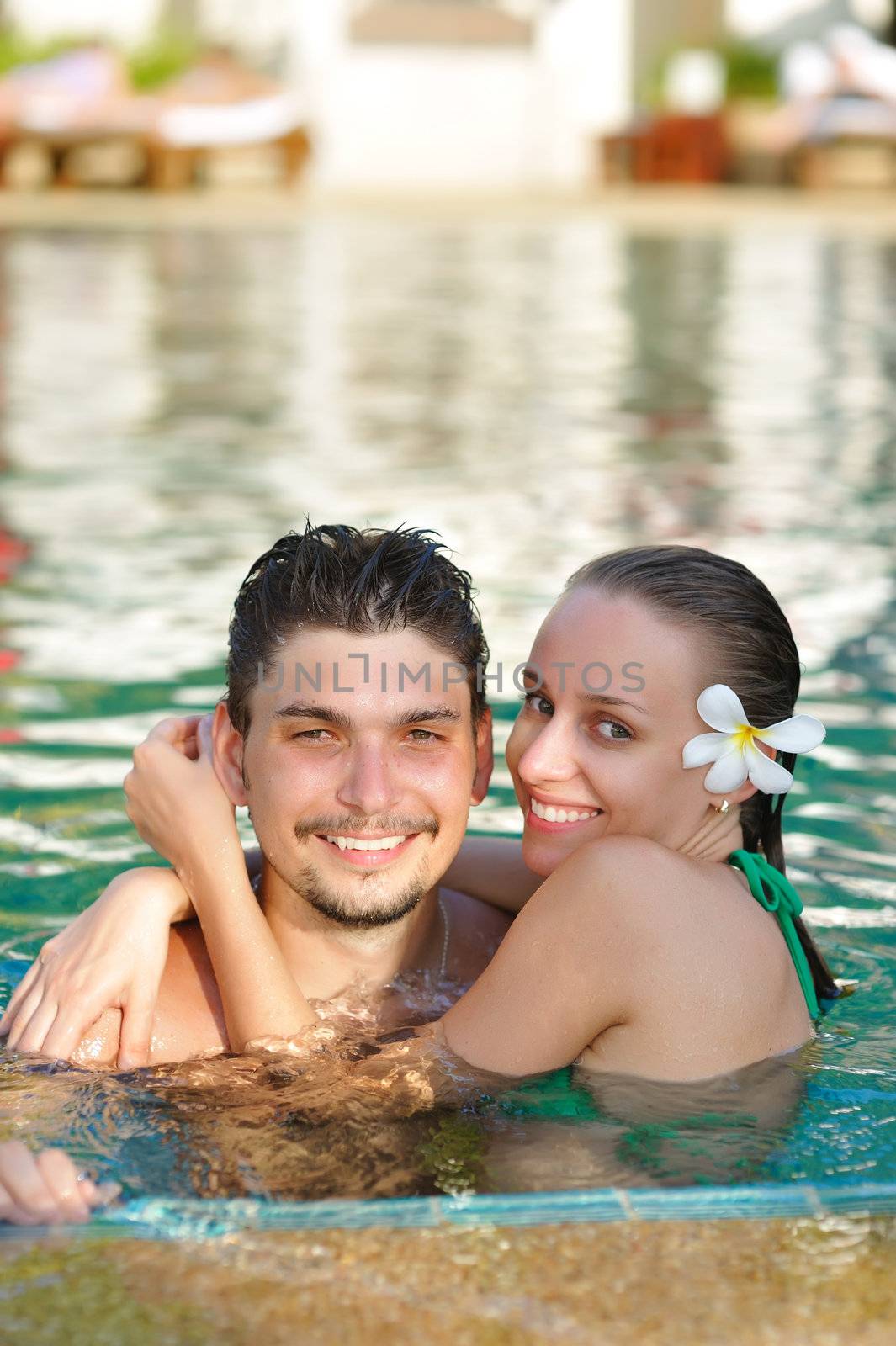 Couple in tropical swimming pool