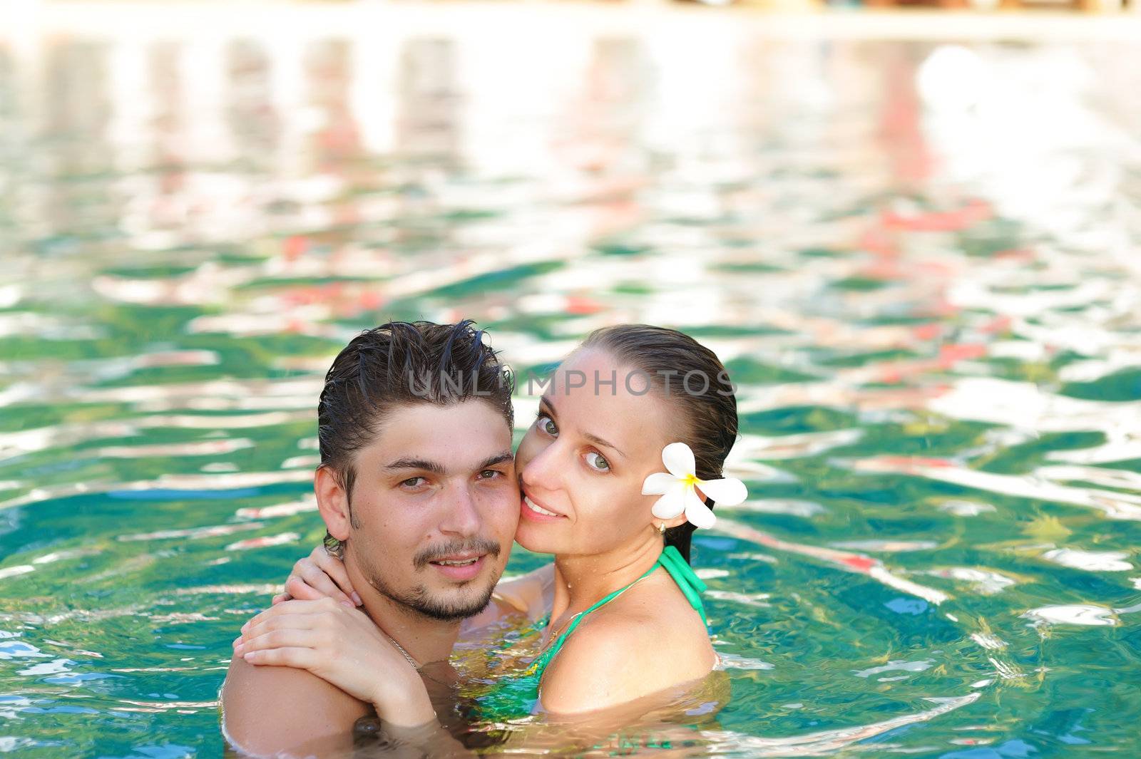 Couple in tropical swimming pool