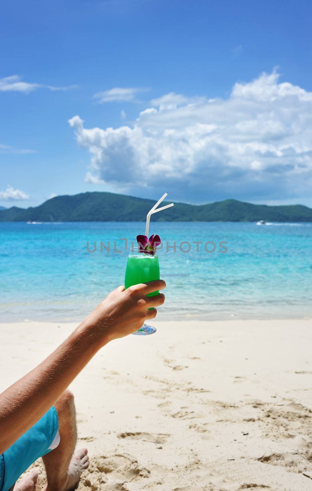 Man on a beach with cocktail