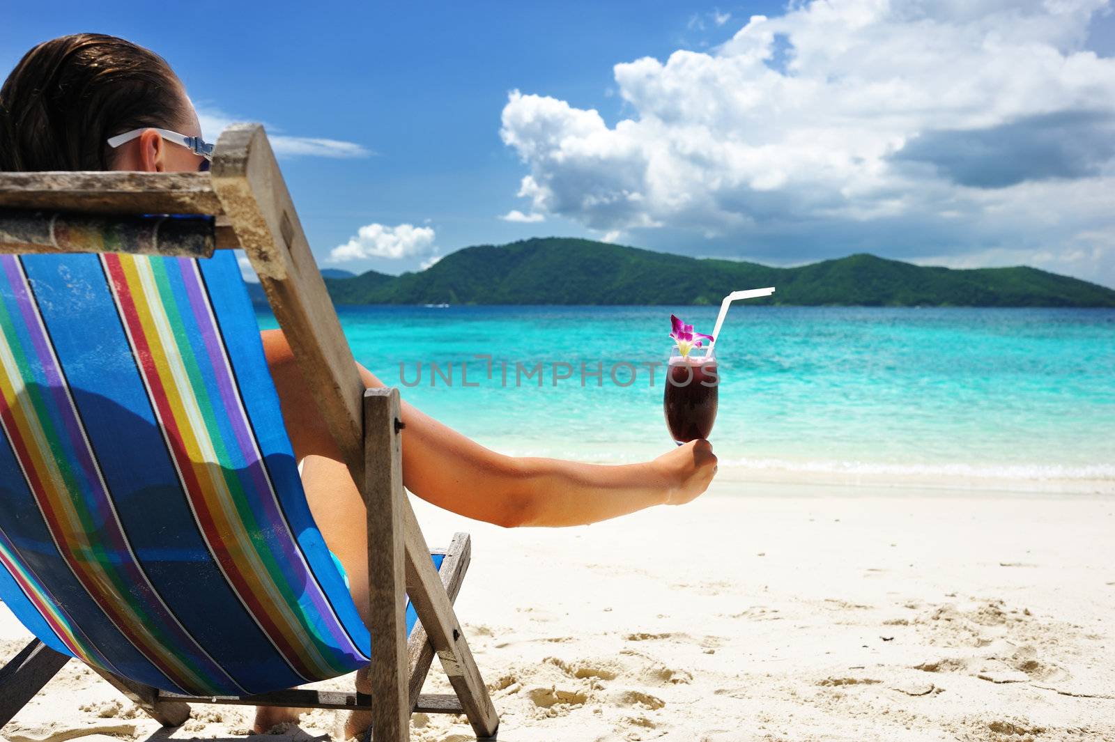 Girl with tropical cocktail on the beach