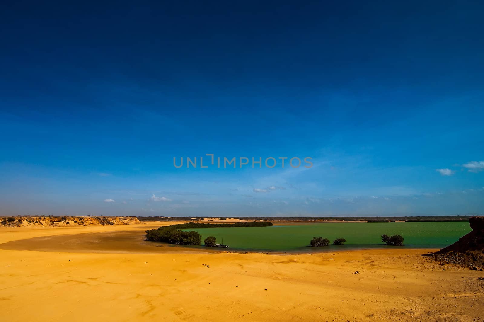 A bay with green water and a deep blue sky in Guajira, Colombia.