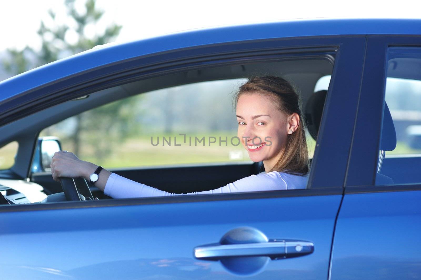 Happy woman in new blue car