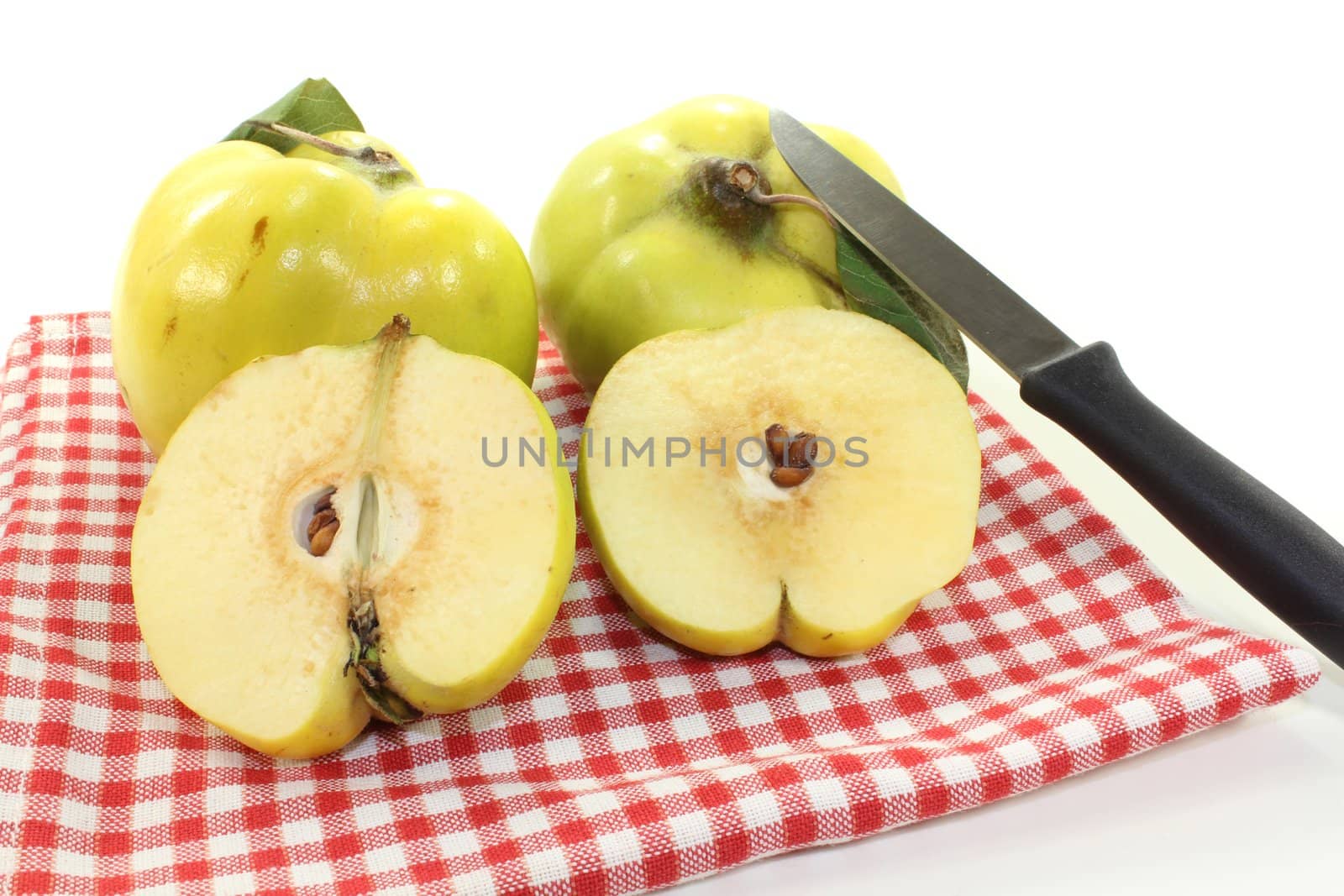 juicy quinces with leaves on a napkin on a light background