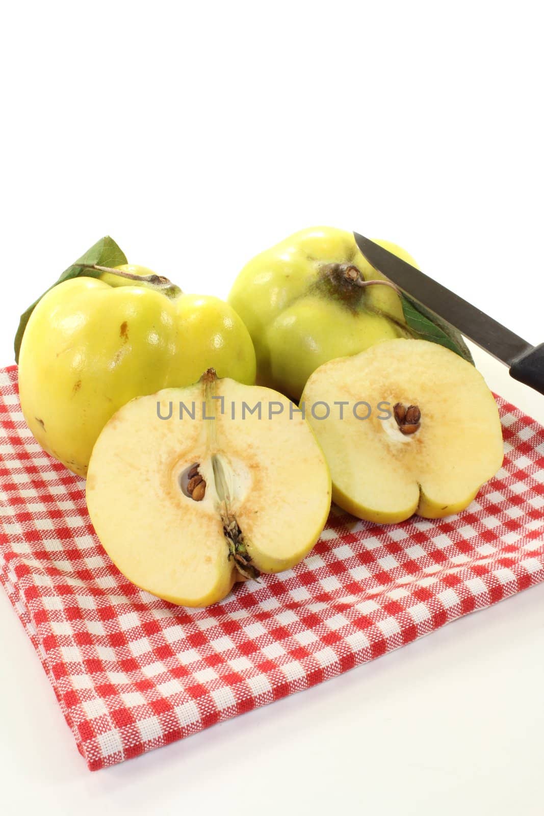fresh juicy quinces with leaves on a napkin on a bright background