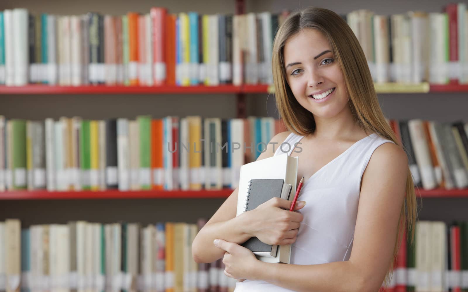 Portrait of a young smiling student in a library