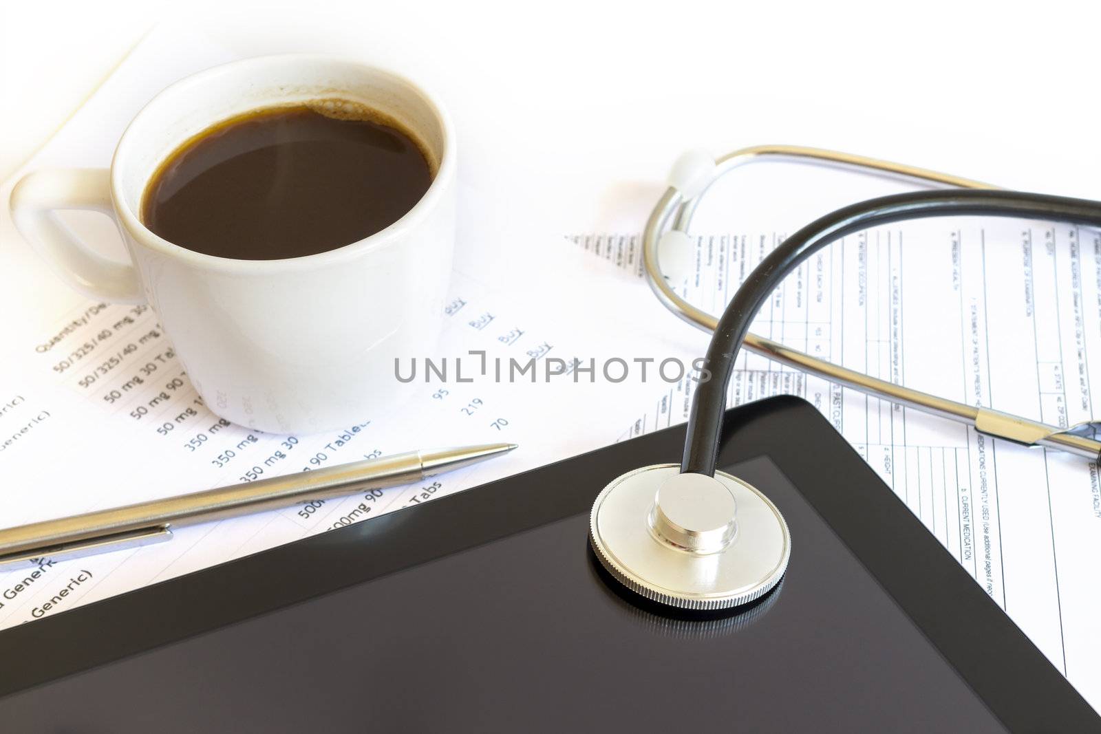 Digital tablet with stethoscope and paperwork