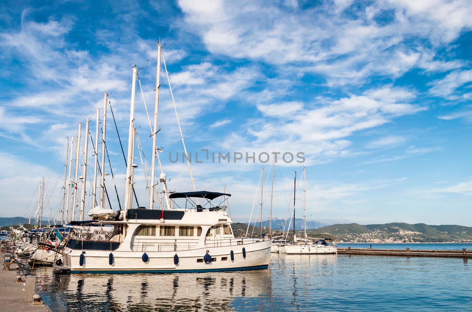 Sailing boat docked in marina harbor in deep blue sky