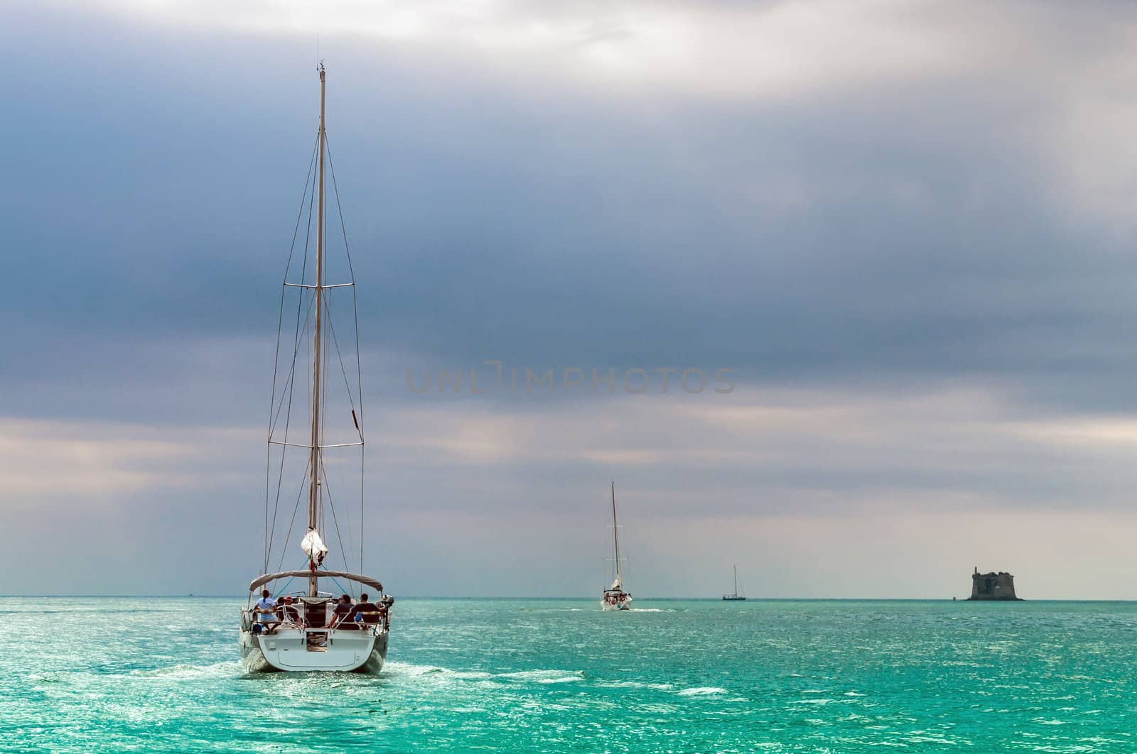 Sailing boat in azure sea in a bad weather sky