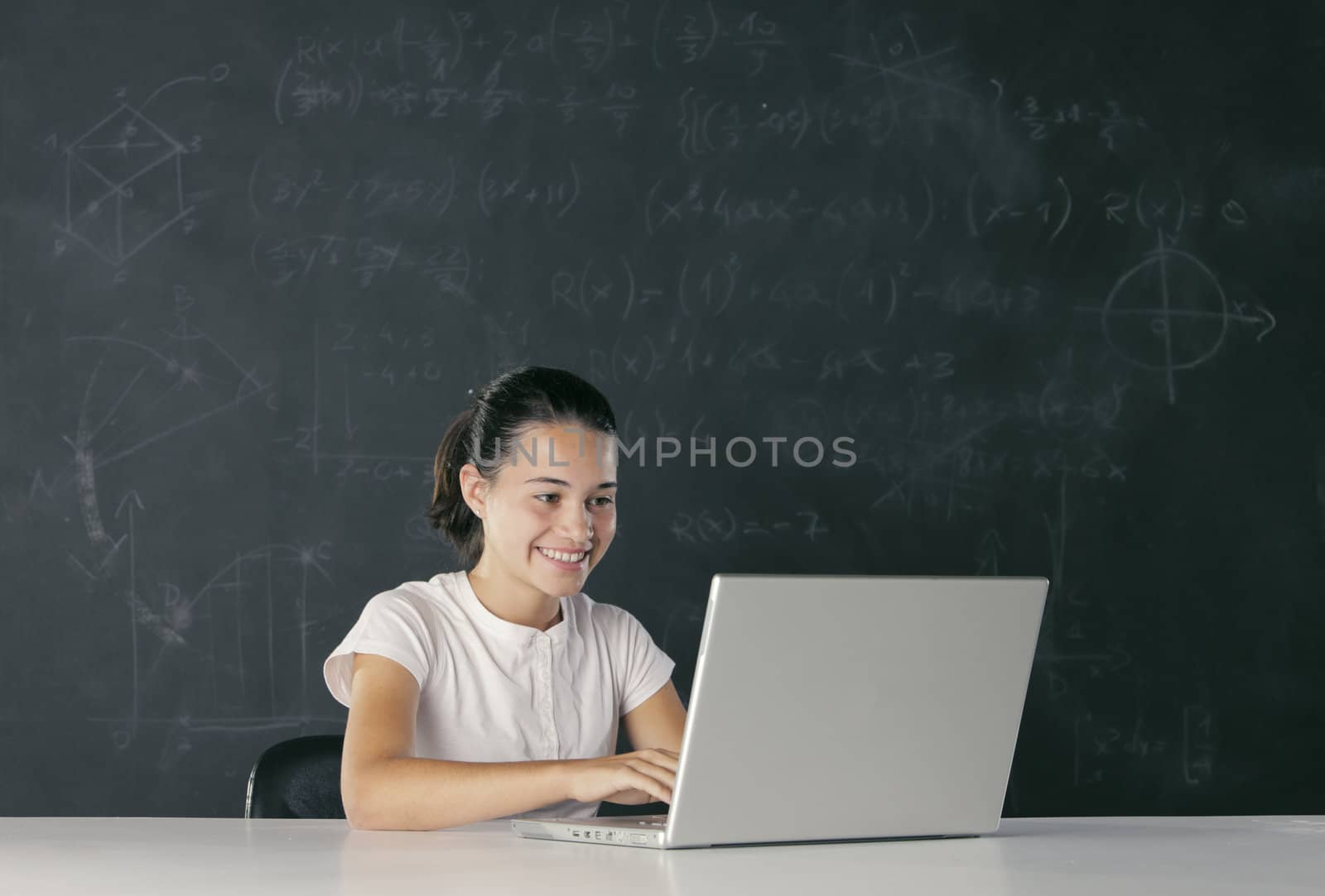 Young girl with laptop, blackboard on background