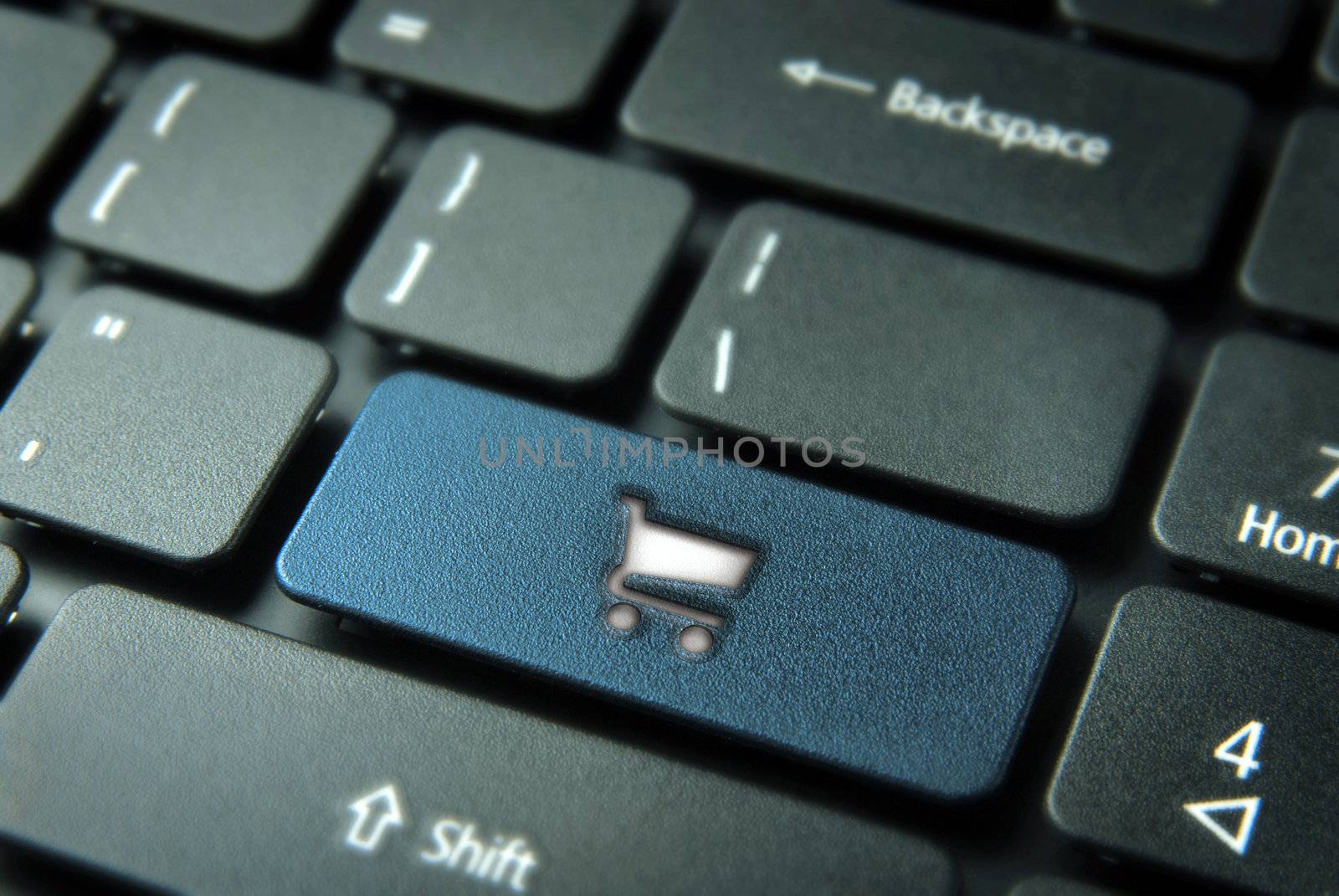 Ecommerce website concept: button with shopping cart icon for purchases online on laptop keyboard. Included clipping path, so you can easily edit it.