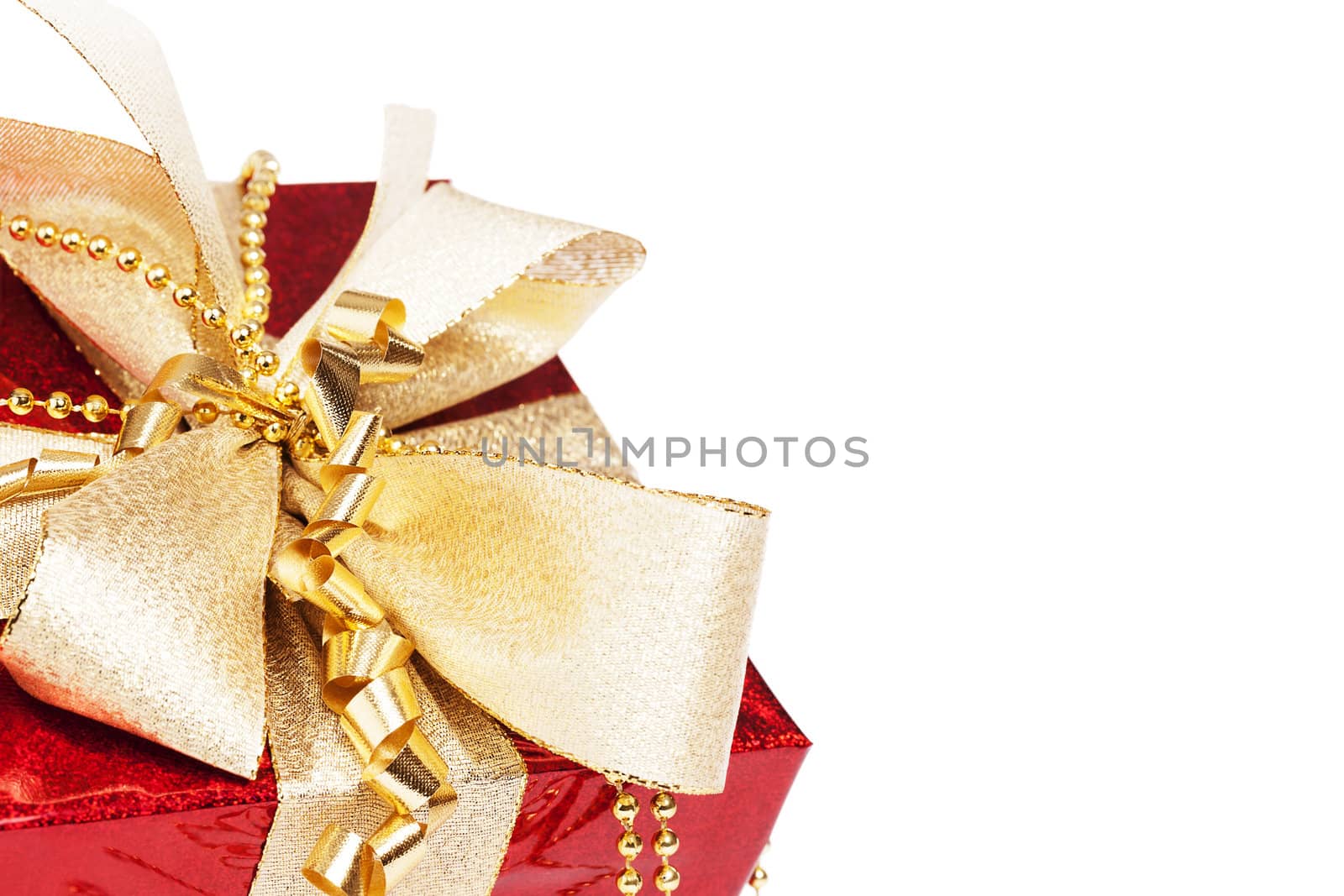 closeup of a red christmas present with golden ribbons on white background