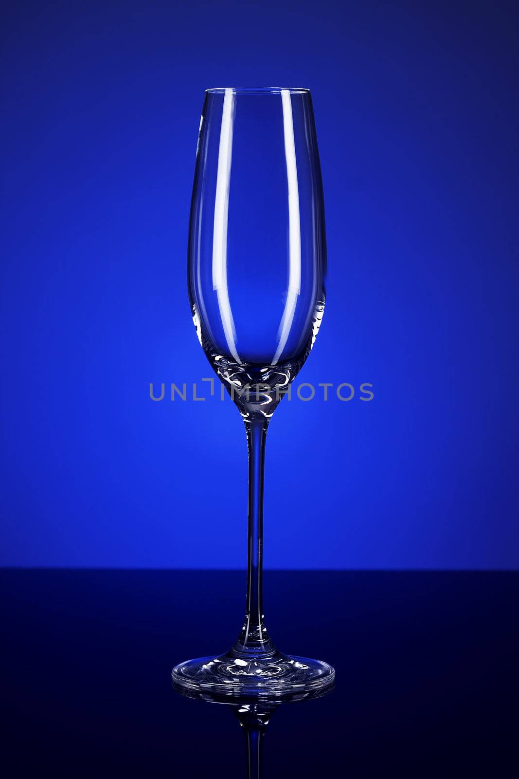 empty champagne glass on blue spot background