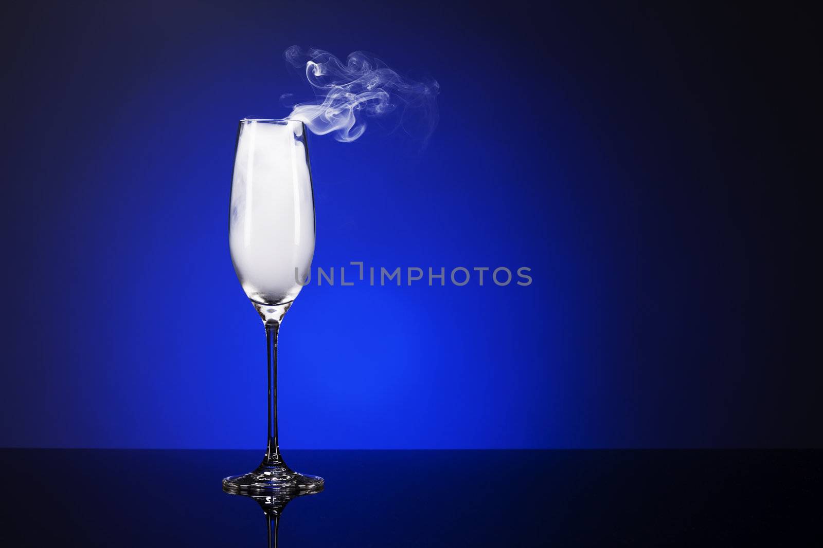 smoking champagne glass on a mirror with blue background light