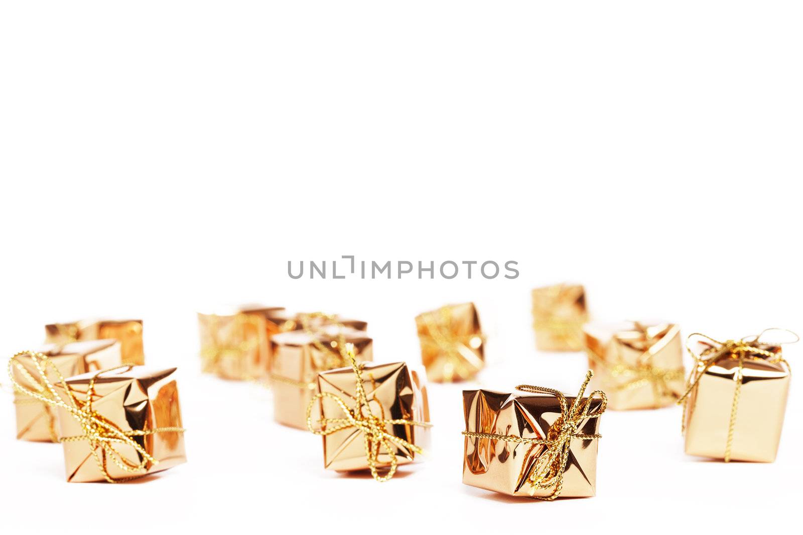 tiny golden christmas presents on white background