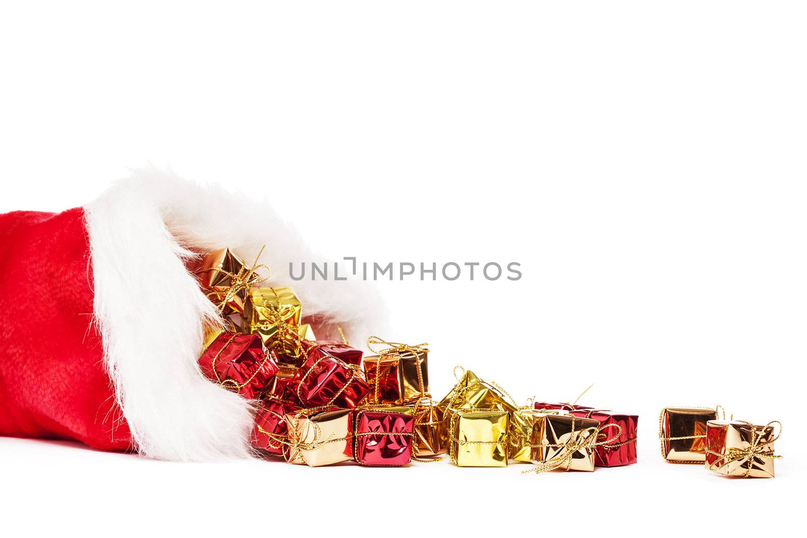 small colorful christmas presents falling from santas hat on white background