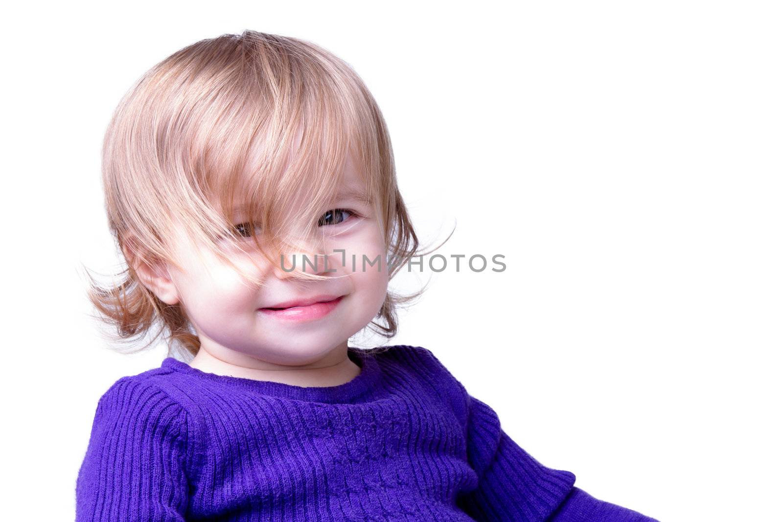Little girl is smiling through her long never cut messy hair. Isolated on white background.