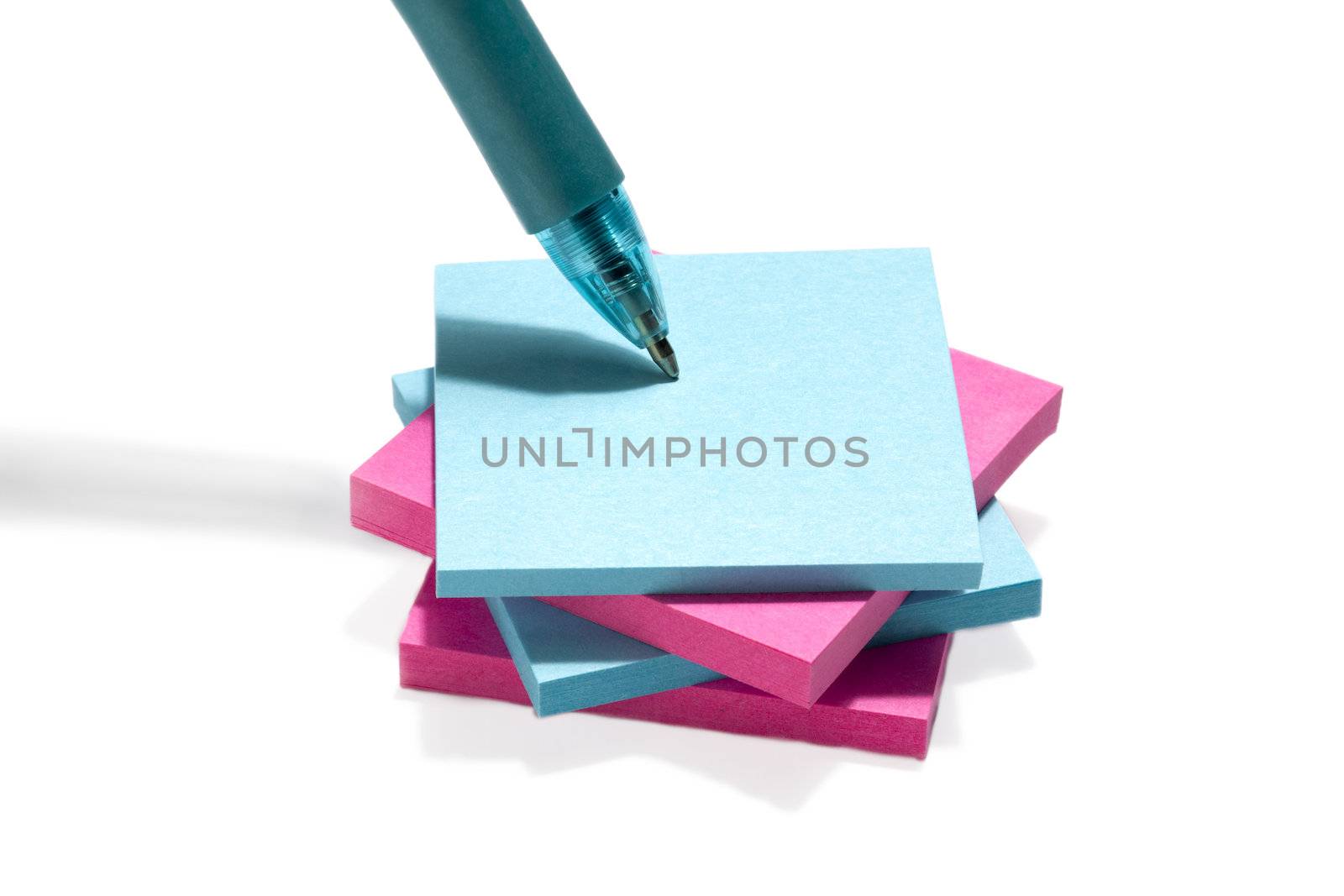 Image of blue and pink post it note paper with pen against the white background 