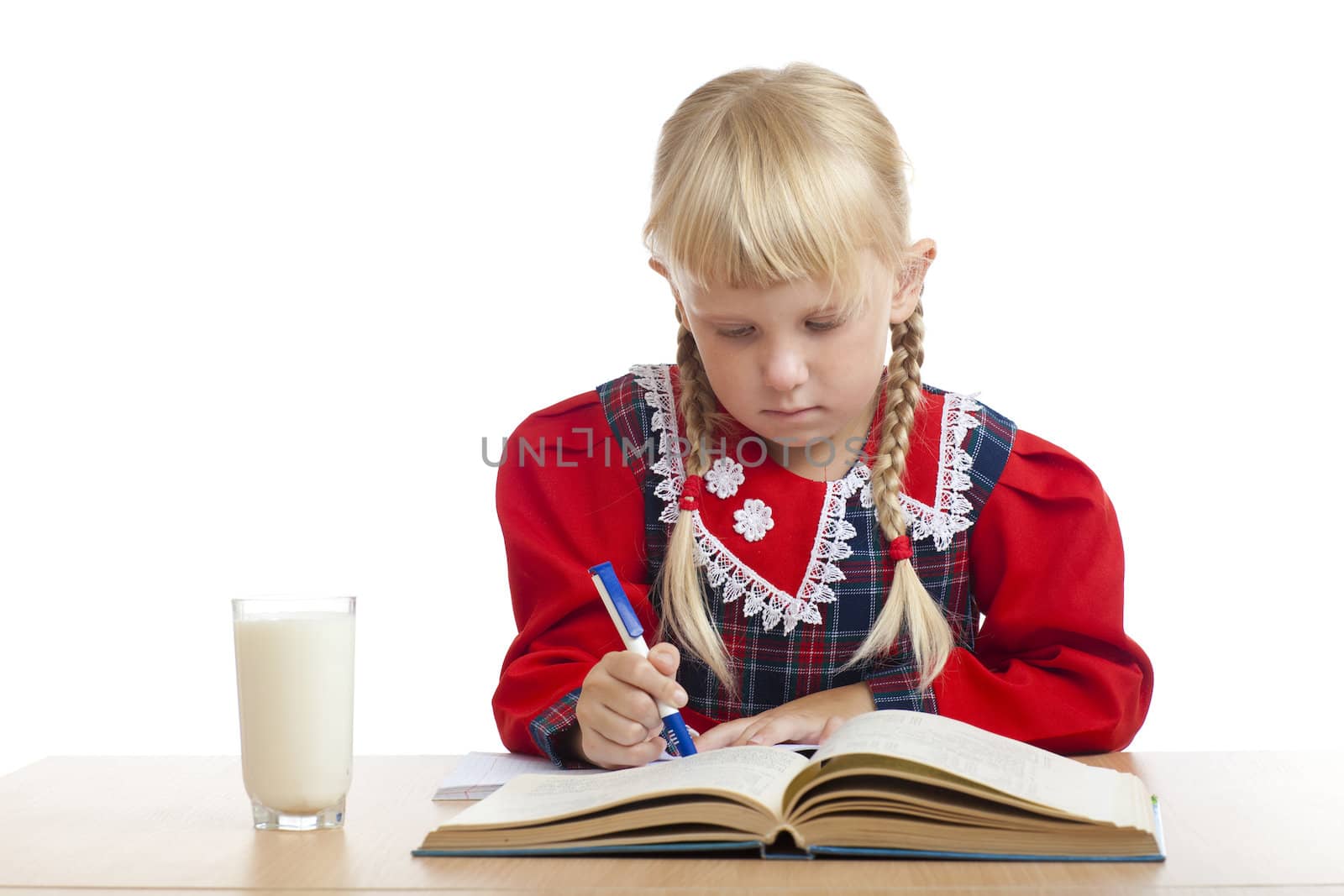 small girl writing and a glass of milk