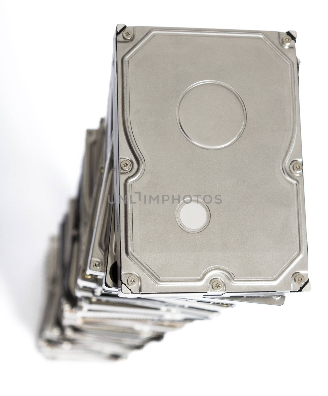 high stack of used hard drives in light background